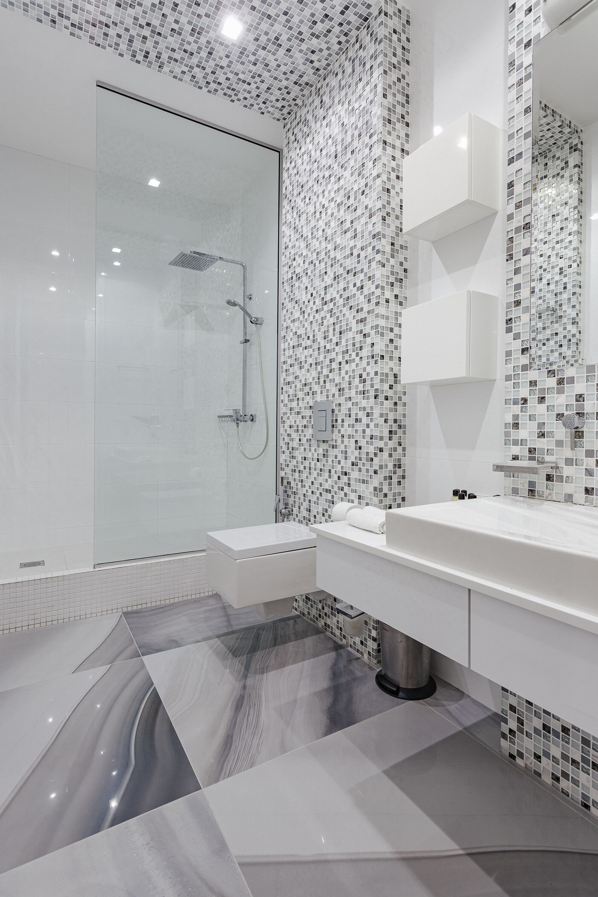A modern bathroom with a glass shower enclosure, a white vanity, and a tiled backsplash.
