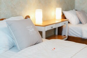 A hotel room with a bed, a nightstand, and two bedside lamps.