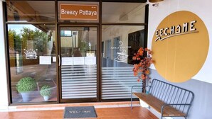 A storefront with a sign reading "Breezy Pattaya" and a large circular sign with "E.E. CHAME" and a message "have a good time".