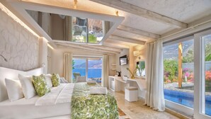 Un dormitorio moderno con una cama grande, un escritorio y vistas al mar.