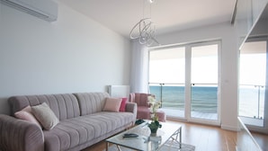 A modern living room with a sofa, armchairs, and a glass coffee table. - Apartament Sailor z widokiem na morze - Nadmorski Luksus (Ustronie Morskie)