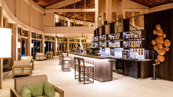 A spacious bar area with multiple seating options, a well-lit bar counter, and a modern interior design.