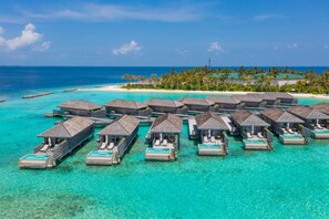 Overwater bungalows with infinity pools, a beach, and clear turquoise water.