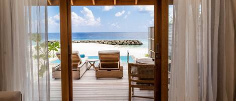 Una terraza de madera con vista a una playa y al océano.