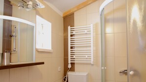 Une salle de bain équipée d’un lavabo, de toilettes et d’une douche à parois de verre.