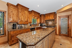A kitchen with wooden cabinets, granite countertops, and a built-in oven.