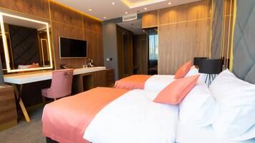 Una habitación de hotel moderna con una cama grande, un escritorio con silla, un tocador con espejo y un televisor.