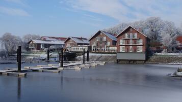 A waterfront property with multiple brick buildings, a dock, and a frozen lake.