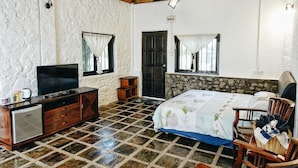 A bedroom with a bed, a TV, a dresser, and a small refrigerator. - Kijalena Beach BnB (Kijal)