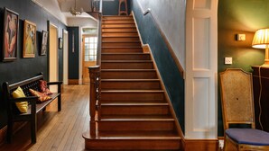 Un escalier en bois avec un banc et une chaise en bas.
