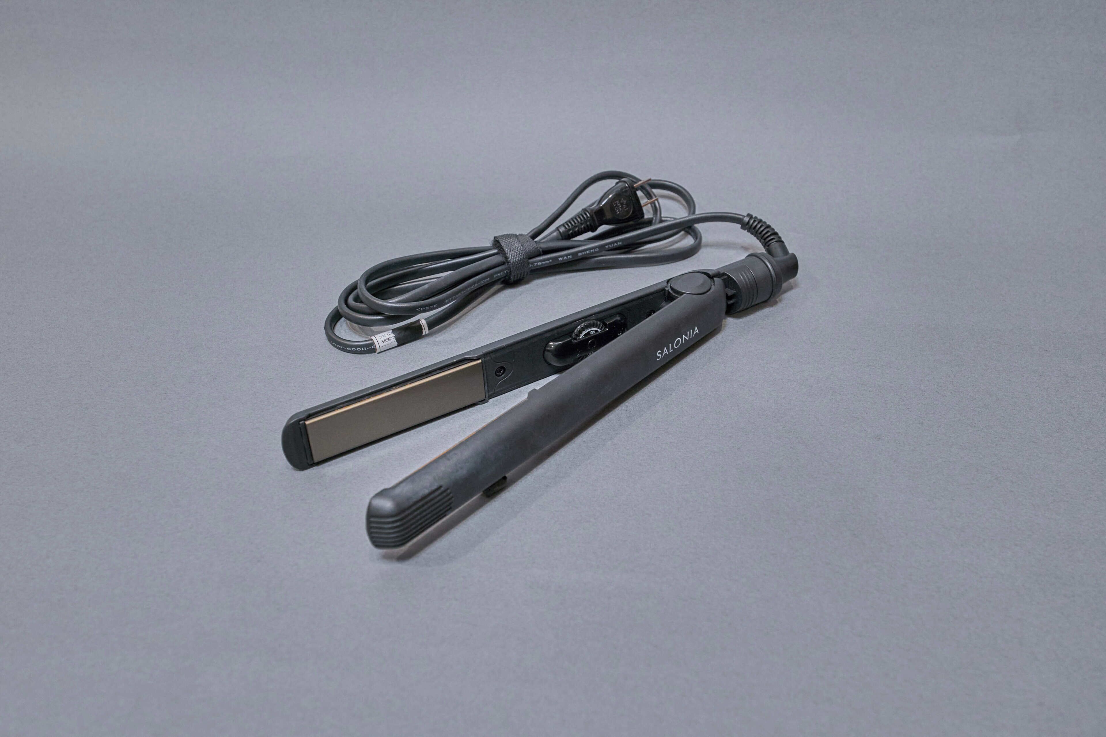 A flat iron with a cord and a power adapter.