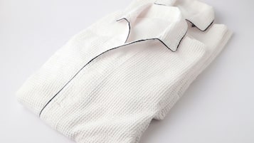 A neatly folded white shirt with a black collar and cuffs.