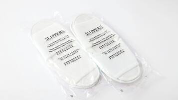 Une paire de chaussons emballés dans un sac en plastique, avec du texte imprimé dessus.