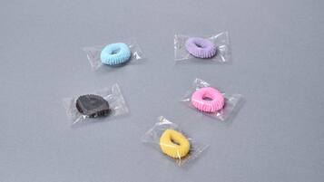 Five small, individually wrapped objects on a grey surface.