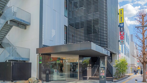 Ein modernes Gebäude mit Glastür, Treppe und einem Schild für das Smile Hotel.