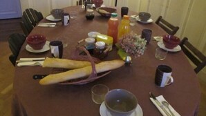 Una mesa de comedor preparada con diferentes platos, bebidas y utensilios.