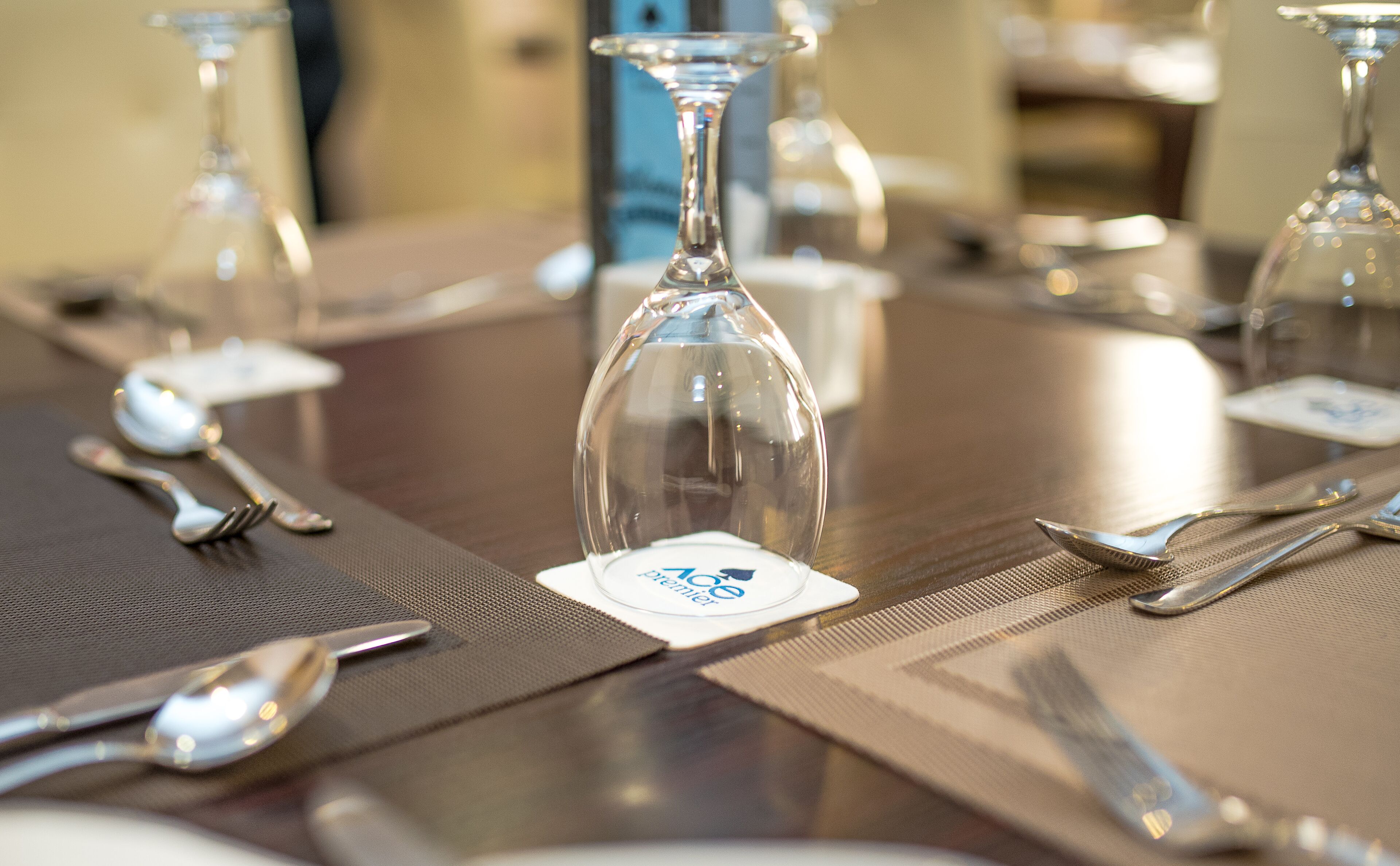 A dining table set with wine glasses, cutlery, and place cards.