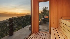 A wooden deck with a view of a sunset over a hilly landscape. - Simurg Inn (Ayvacik)