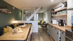 A modern kitchen with wooden countertops, a built-in oven, and a dining area with a wooden table and chairs.