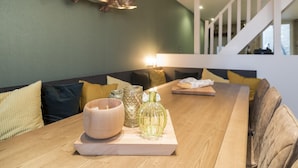 A dining area with a wooden table, a fish mounted on the wall, and a staircase in the background.