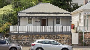 A two-story building with a balcony, stone foundation, and a metal roof. - Bluestone Cottage Launceston ITAS (Launceston)