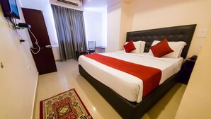 Habitación de hotel con una cama grande, un escritorio y una silla.