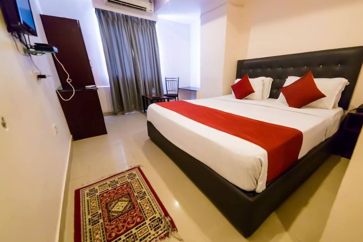 Habitación de hotel con una cama grande, un escritorio y una silla.
