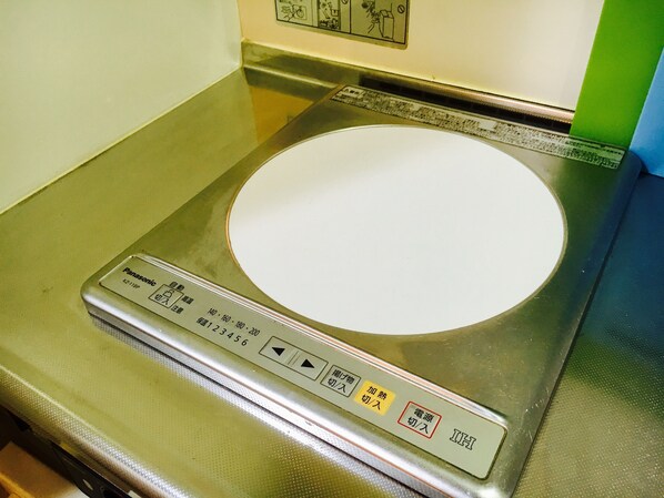 A stainless steel induction cooktop with a digital control panel.