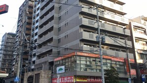 A multi-story building with a commercial ground floor, featuring various storefronts and a vending machine. - Diamante Yakuin (Fukuoka)