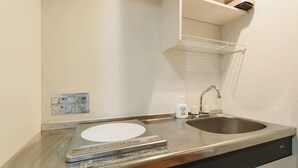 A bathroom with a sink, a scale, and a shelf with toiletries. - Diamante Yakuin (Fukuoka)