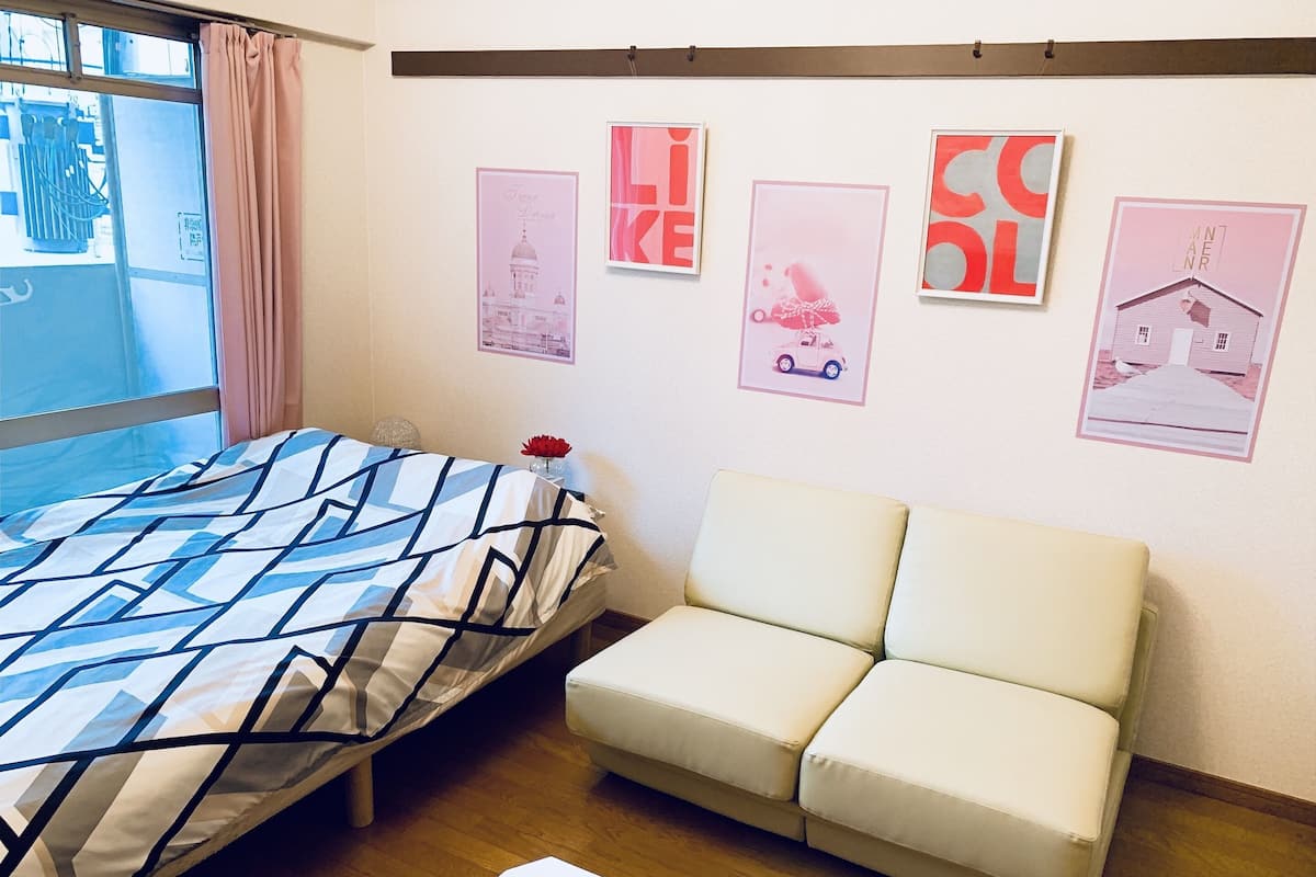 Una habitación con cama, sofá y decoración en la pared.