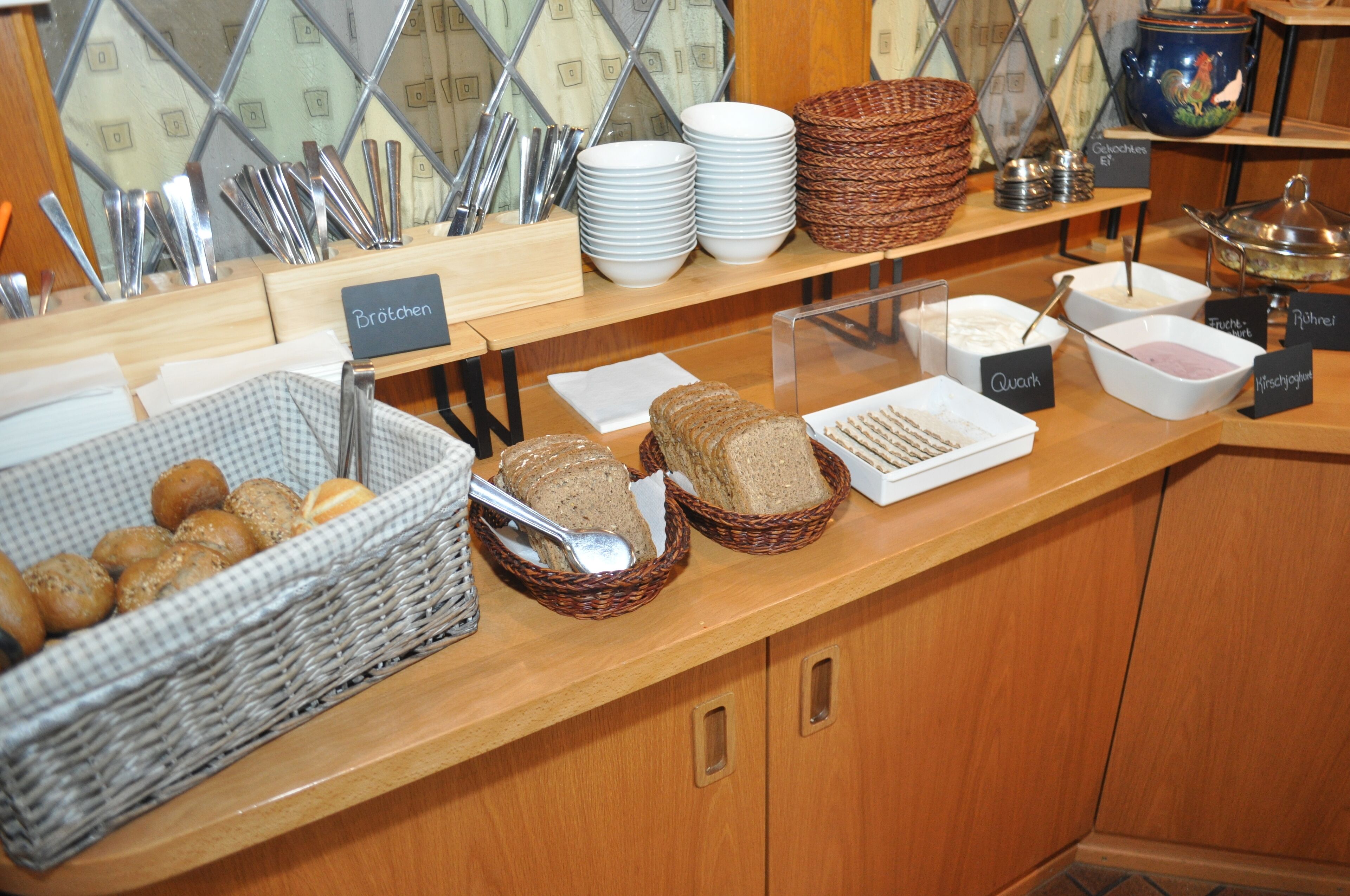 Balcão de buffet com diversos alimentos e utensílios.
