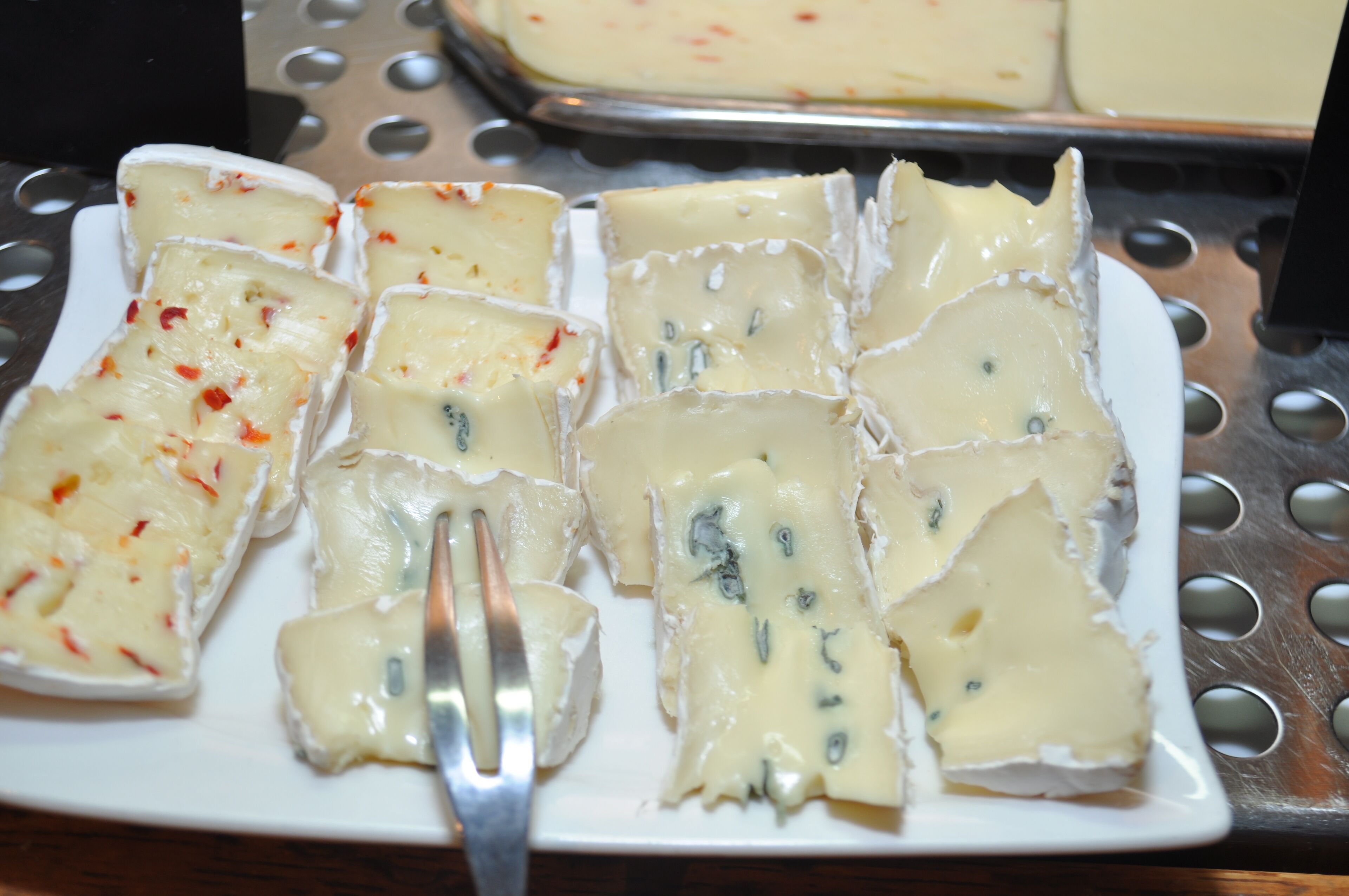 Un piatto di cubetti di formaggio con una forchetta.