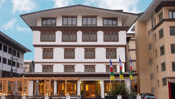 A multi-story building with traditional architectural features, including patterned window frames and a central entrance. - Lemon Tree Hotel Thimphu (Thimphu)