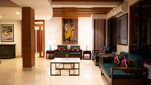 A spacious living room with a large sofa, a coffee table, and two armchairs. There is a painting on the wall and a wooden floor. - Lemon Tree Hotel Thimphu (Thimphu)