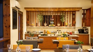 A restaurant with a wooden interior, a counter with various food items, and seating arrangements. - Lemon Tree Hotel Thimphu (Thimphu)