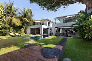 A modern house with a swimming pool, a wooden deck, and lush greenery. - Beautiful Villa With Private Pool, Bali Villa 2001 (Seminyak)