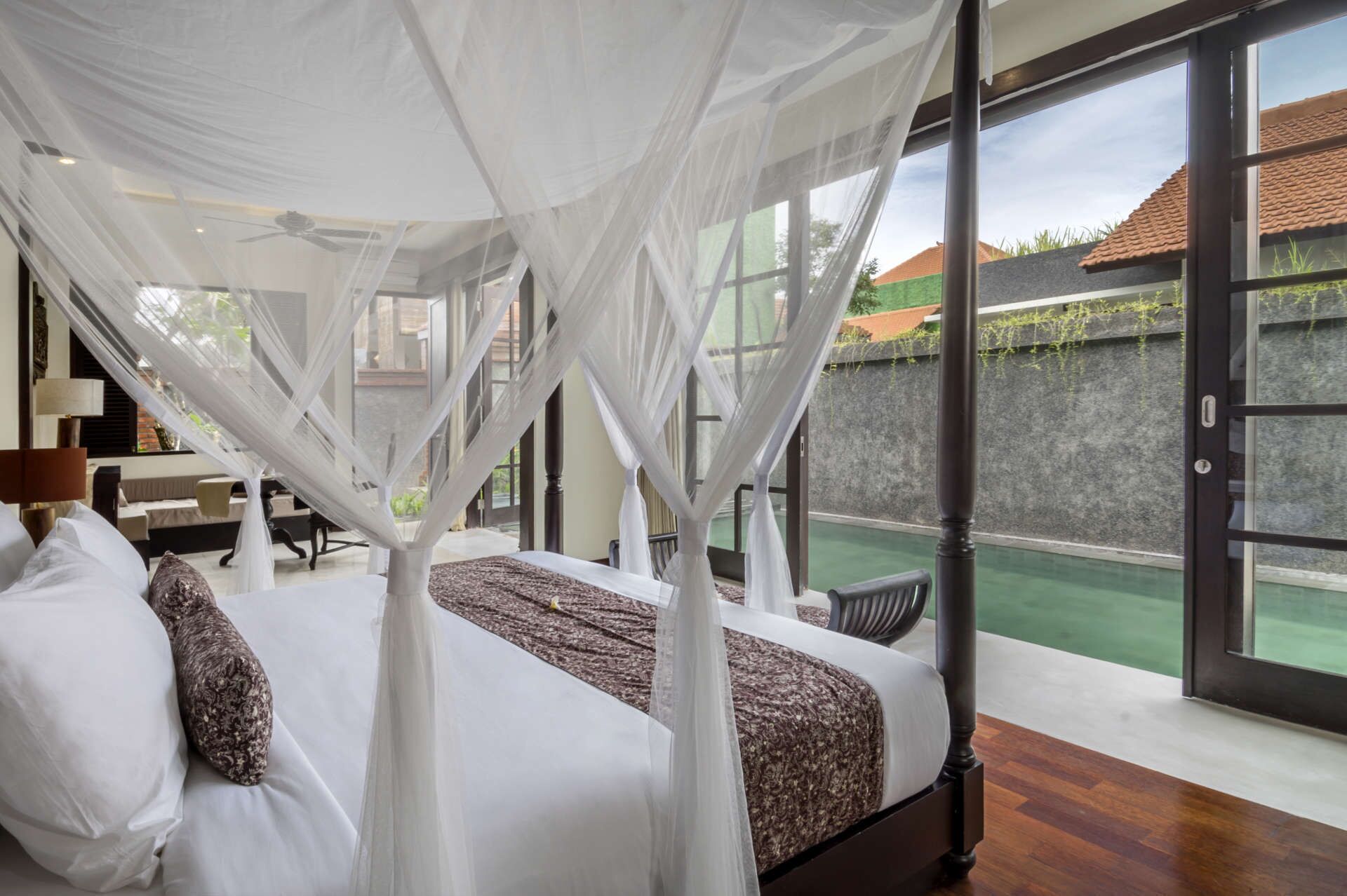 Un dormitorio con cama con dosel, un ventanal y vistas al exterior.
