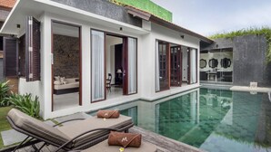 A modern house with a swimming pool, a lounge area with sun loungers, and a brick wall. - Beautiful Villa With Private Pool, Bali Villa 2014 (Kerobokan)