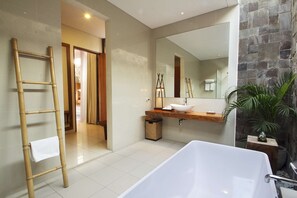 A modern bathroom with a large bathtub, a wooden vanity, a mirror, and a potted plant. - Luxury 2 Bedroom Villa With Private Pool, Bali Villa 2033 (Seminyak)