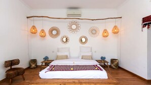 A bedroom with a wooden bed, white bedding, and decorative wall mirrors. - Villa for Rent in Bali 2046 (Seminyak)