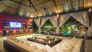 A spacious lounge area with a bar, comfortable seating, and a pool view. - Bali Villa Near the Beach, 2064 (Seminyak)