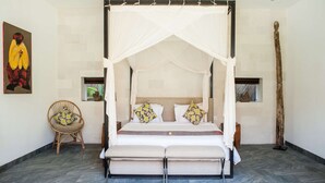 A four-poster canopy bed with a mattress, pillows, and a headboard.