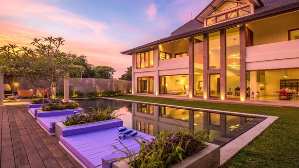 Une maison moderne dotée d’une grande piscine, d’un espace extérieur aménagé et d’un jardin bien entretenu.