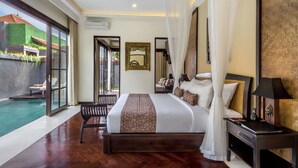 A spacious bedroom with a large bed, a bedside table, a nightstand, and a view of a swimming pool. - Beautiful Villa With Private Pool, Bali Villa 2012 (Kerobokan)
