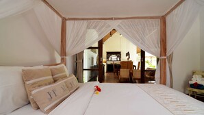 A bedroom with a canopy bed, a view of the dining area, and a small table with towels. - Luxury Villa in Bali near Beach, Bali Villa 2031 (Ubud)