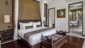 A spacious bedroom with a large bed, a canopy, a mirror, and a view of a patio with outdoor furniture. - Villa for Rent in Bali 2010 (Kerobokan)