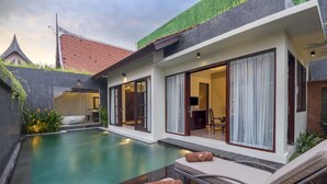 A modern house with a swimming pool, large sliding glass doors, and a well-maintained garden. - Villa for Rent in Bali 2010 (Kerobokan)