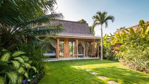 A house with a covered patio, a lawn, and tropical plants. - Luxury 12 Bedroom Villa With Private Pool, Bali Villa 2027 (Kerobokan)