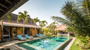 A pool area with lounge chairs, a thatched-roof structure, and lush greenery. - Luxury 12 Bedroom Villa With Private Pool, Bali Villa 2027 (Kerobokan)
